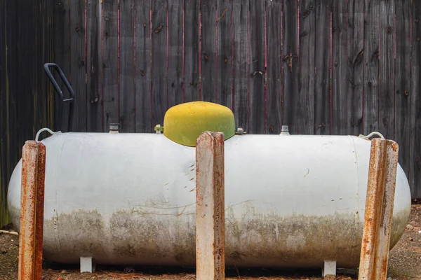 Augusta, Ga USA - 03 17 21: Outdoor propane tank with a green top and brown wooden fence