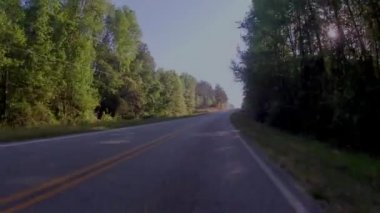 Burke County, Ga USA - 04: 21 Uzun, dolambaçlı kırsal yol, sabahın erken saatlerinde güneş parlarken 