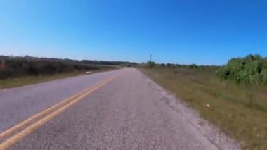 Burke County, Ga USA - 04: 21: kırsal bir köy yolu tarım arazisi çöplüğü ve yol kenarındaki traktörlerin tarlayı sürmesi 