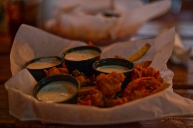 Kızarmış karidesli soslar ve bulanık arkaplanlı patates kızartmaları.