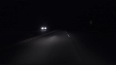 POV FPV Blurry night scene passing headlights from a car on a highway