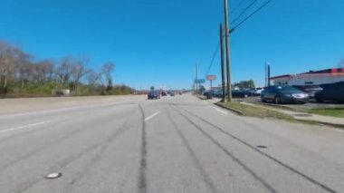 Augusta, Ga USA - 02 21 21: POV FPV driving on an urban highway with industrial smoke stack clear blue sky