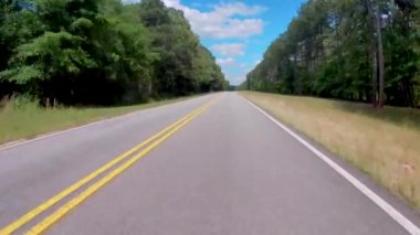 FPV Driving on a country rural road with lush green forest and blue sky with clouds no traffic - Georgia