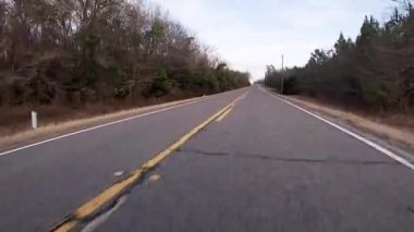 Burke County, Ga USA - 01: 25: POV FPV tarla cevizi bahçeleri ve binaları olan uzun bir köy yolunda sürüyor