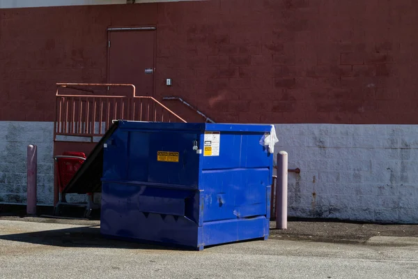 Augusta, Ga USA - 03 04 21: Blue dumpster behind a building shopping center 