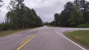 POV FPV yazın Gürcistan 'da kırsal bir yolda giderken bir kır yolu üzerinde yemyeşil bir orman görülür.