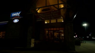 Augusta, Ga USA - 0121: Geceleri IHOP restoranının girişi aydınlık bina ve sokak tabelası - Hwy 25