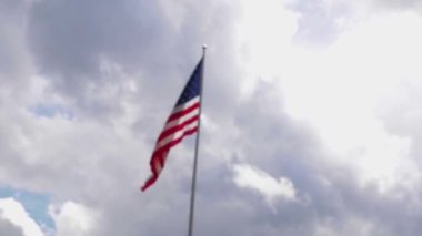 Bulutlu bir günde rüzgarda dalgalanan Amerikan Bayrağı