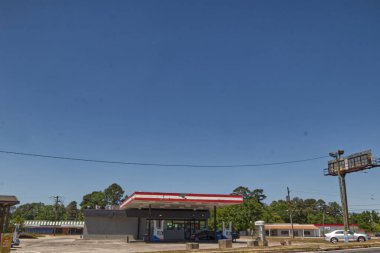 Augusta, Ga USA - 04: 22: Şehir benzin istasyonu ve arka planda park halindeki araçlar ve klasik binalar 