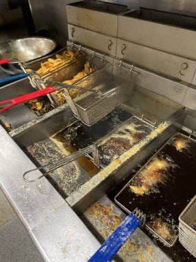 Endüstriyel yağ fırınında kızartma ve tavuk pişiyor.