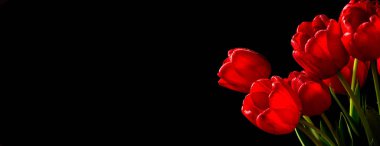 Siyah bir zemin üzerinde büyük bir zemin üzerinde kırmızı laleler buketi.