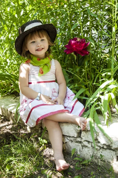 Kırmızı bir Şakayık ile şapkalı küçük kız