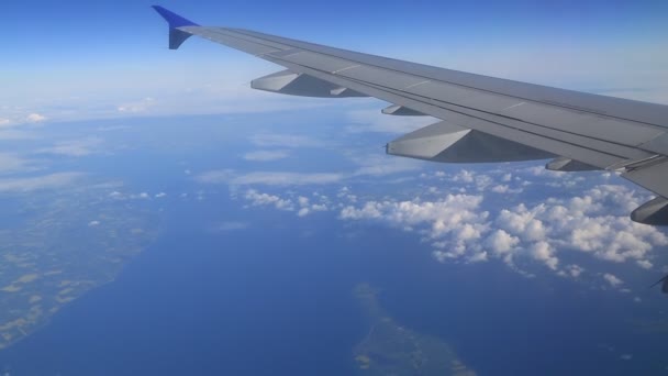 Scene from window of airplane. Clouds, landforms and sea. — Stock Video