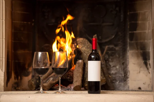 Şöminenin yanında şarap ve şarap cam.