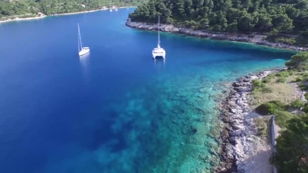 Aerial, panormaic, scene traveling from a rocky coast to a catamaran. — Stock Video
