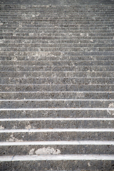 Vintage steps made of rock in an old exterior stairs in a park in paris.