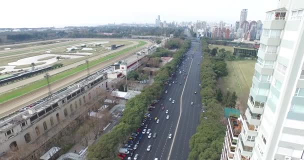 Aerial, panoramic scene with drone of big avenue and green park with lakes. Camera moves to appreciate the hippodrome. — Stock Video