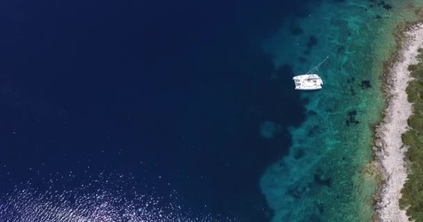 Scène aérienne de drone sur la côte dalmate, Croatie. Détail du catamaran ancré dans un lieu transparent et paradisiaque . — Video