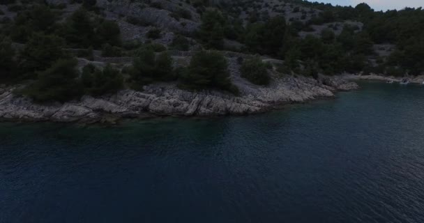 Escena aérea de costa en una bahía croata. Detalle de catamarán anclado. Drone se mueve a los lados forman costa natural para cerrar de barco . — Vídeo de stock