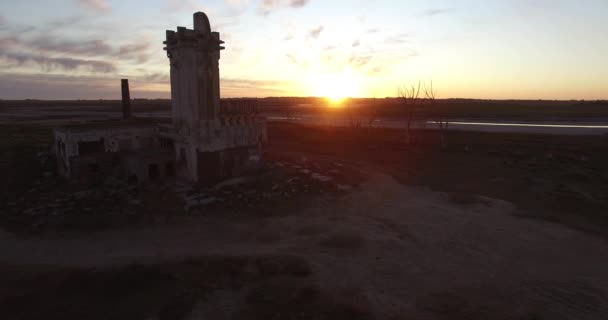 Luchtfoto Drone scène van een verlaten slachthuis bij zonsondergang, omgeven door dode bomen in Epecuen in buenos aires Argentinië. Gruwelijke en eng exterieur panorama. Camera reizen langzaam naar de voorzijde. — Stockvideo