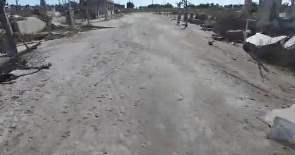 Drohnen-Szene über zerstörter, verlassener Stadt. graue dreckige Straße. epecuen argentina. Kamera fliegt schnell in Bodennähe. — Stockvideo