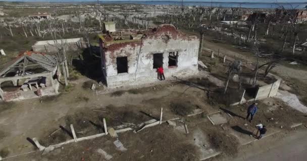 Drohnen-Szene einer verlassenen, zerstörten Stadt. Abgerissene, alte, verfallene Häuser. Die Kamera erfasst die Nachbarschaft von der Nahaufnahme bis zum Panoramablick. Menschen auf den einsamen Straßen. — Stockvideo