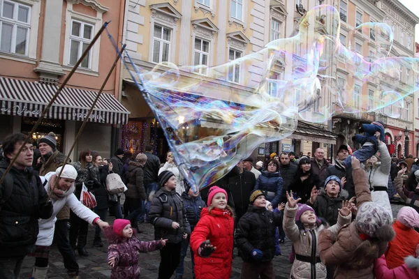 Lvov, Ukrajina - 19 prosince 2015: Děti si hrají s mýdlové bubliny. — Stock fotografie