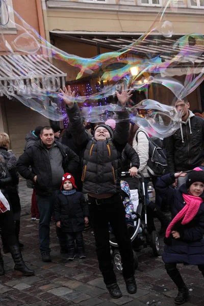 Lviv, Oekraïne - 19 December 2015: Kinderen spelen met zeepbellen. — Stockfoto