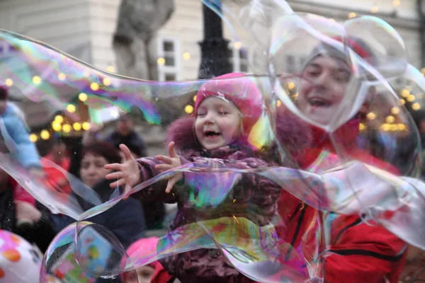 LVIV, UCRÂNIA - DEZEMBRO 19, 2015: Crianças brincando com bolhas de sabão . Fotos De Bancos De Imagens