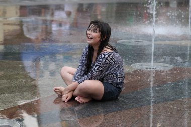 Kharkiv, Ukrayna - 1 Haziran 2015: Çeşme oynayan genç kız.