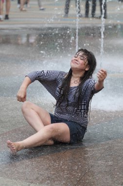 Kharkiv, Ukrayna - 1 Haziran 2015: Çeşme oynayan genç kız.