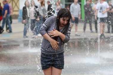 Kharkiv, Ukrayna - 1 Haziran 2015: Çeşme oynayan genç kız.