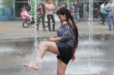 Kharkiv, Ukrayna - 1 Haziran 2015: Çeşme oynayan genç kız.