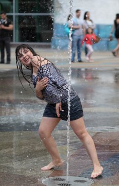 Kharkiv, Ukrayna - 1 Haziran 2015: Çeşme oynayan genç kız.
