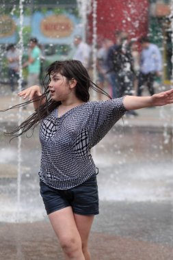 Kharkiv, Ukrayna - 1 Haziran 2015: Çeşme oynayan genç kız.