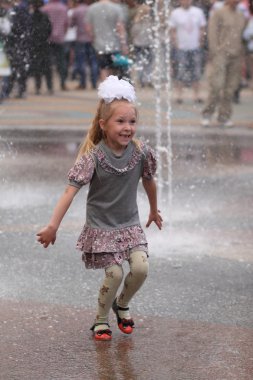 Kharkiv, Ukrayna - 1 Haziran 2015: Çeşme oynayan genç kız.