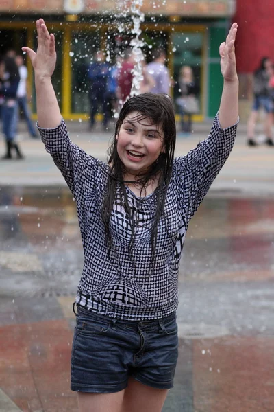 Kharkiv, Ukrayna - 1 Haziran 2015: Çeşme oynayan genç kız.
