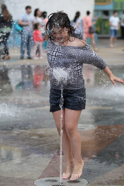 Kharkiv, Ukrayna - 1 Haziran 2015: Çeşme oynayan genç kız.