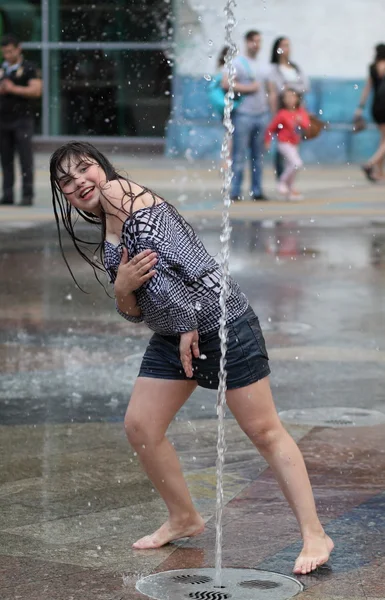 Kharkiv, Ukrayna - 1 Haziran 2015: Çeşme oynayan genç kız.