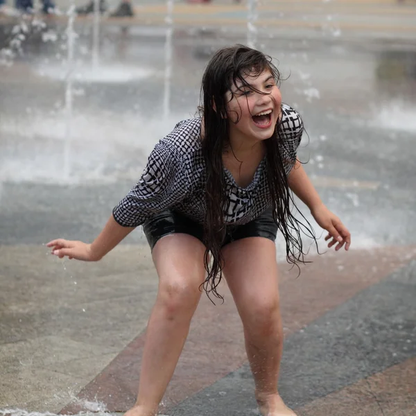 Харьков, Украина - 1 июня 2015 года: Девушка-подросток играет в фонтане . — стоковое фото