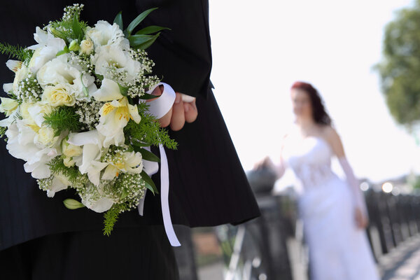 Groom hides bouquet for bride