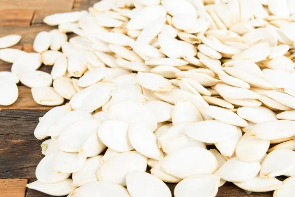 Pumpkin seeds on wooden background. — Stock Photo, Image