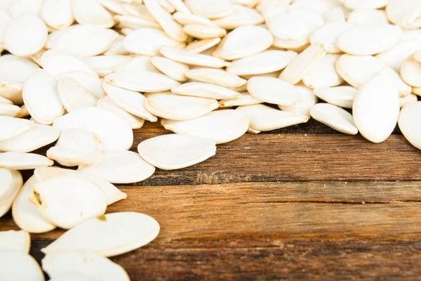 Pumpkin seeds on wooden background. — Stock Photo, Image