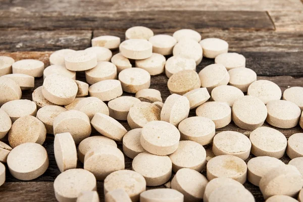 Gyógyszert tablettát a fából készült háttér. — Stock Fotó