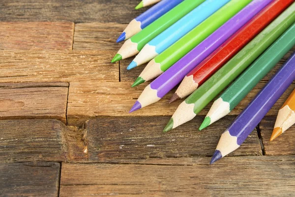 Fargede blyanter på trebakgrunn. – stockfoto