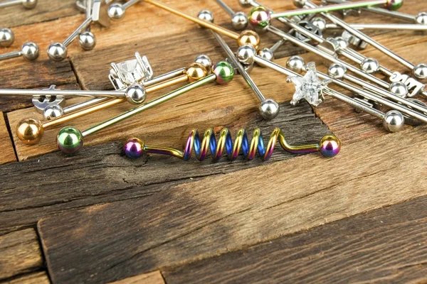 Joyería para piercing sobre fondo de madera . — Foto de Stock