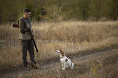 Avcı ve Rus köpeği ormanın yakınındaki toprak yolda. Resim büyük av gezisi sırasında çekildi. Av dönemi, sonbahar sezonu açıldı..