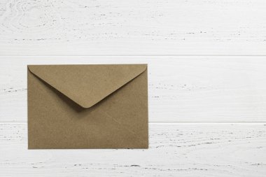 Kahverengi zarf ahşap arka planda. Metin için boşluk.