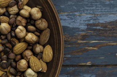 Ahşap yüzeyde ahşap kasede fındık karıştırdım. Fındık çeşitleri. Üst görünüm.