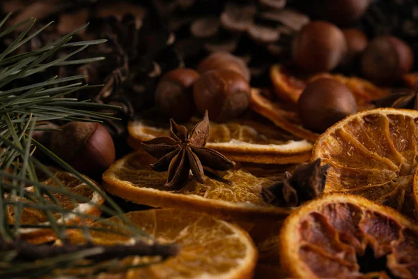 Weihnachtlicher Hintergrund Mit Tannenzweigen Haselnüssen Anissternen Und Getrockneten Orangen Auf — Stockfoto